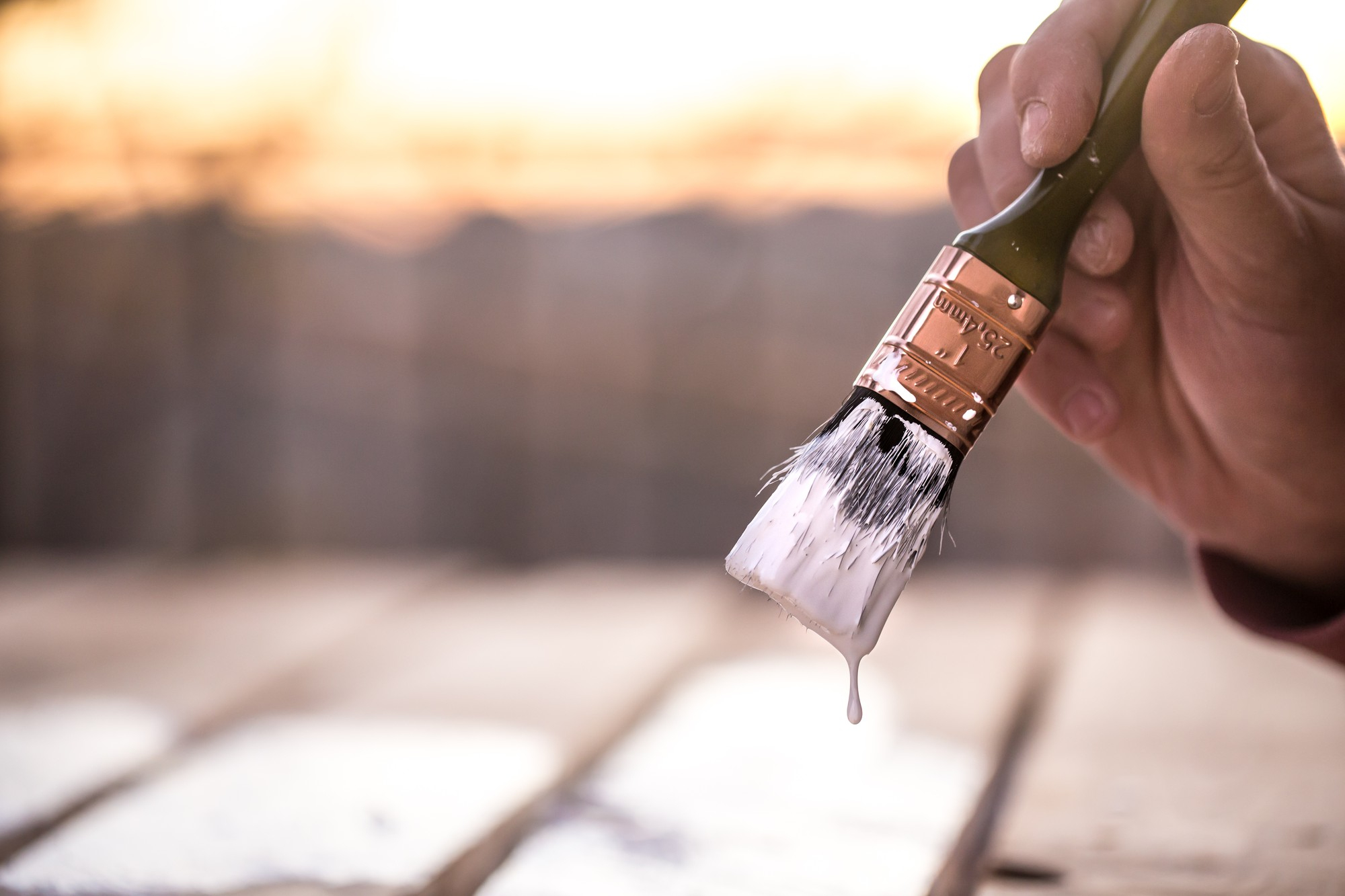 male-hand-paints-with-white-paint-wood-painting-concept-close-up-place-text